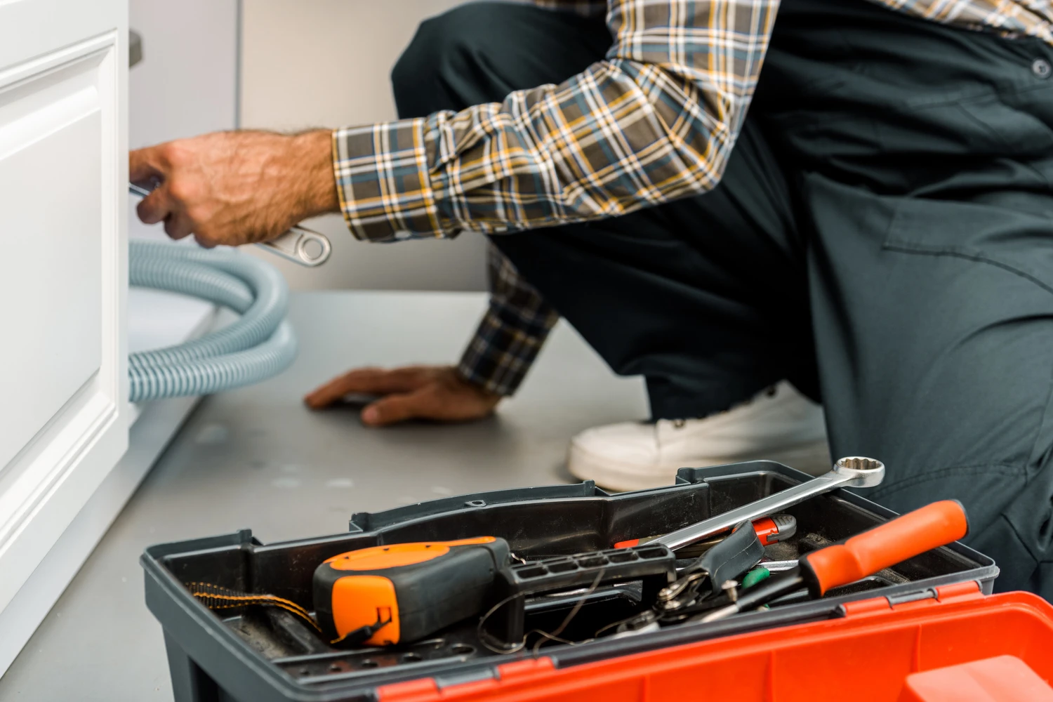 cropped image of plumber repairing broken sink in kitchen<br />