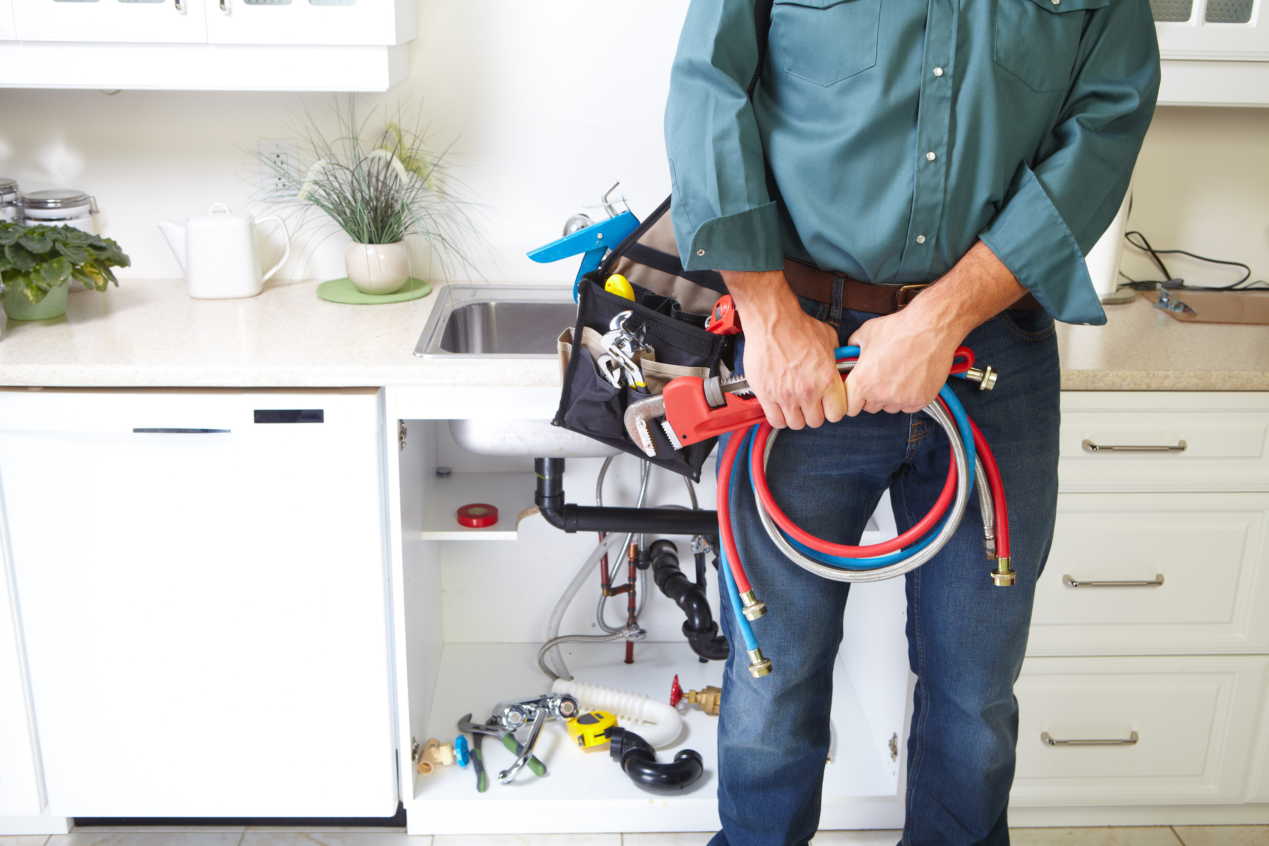 Plumber with Plumbing tools on the kitchen. Renovation.
